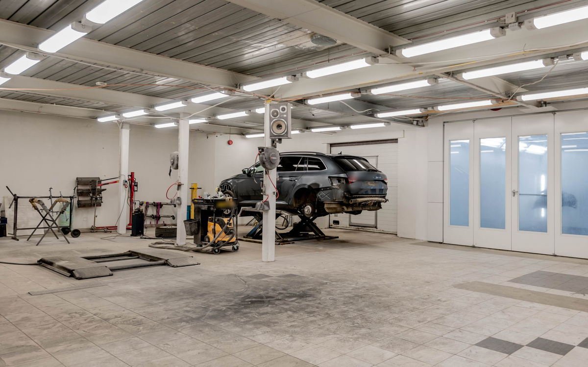 Vehicle raised on a two-post lift inside a professional automotive workshop
