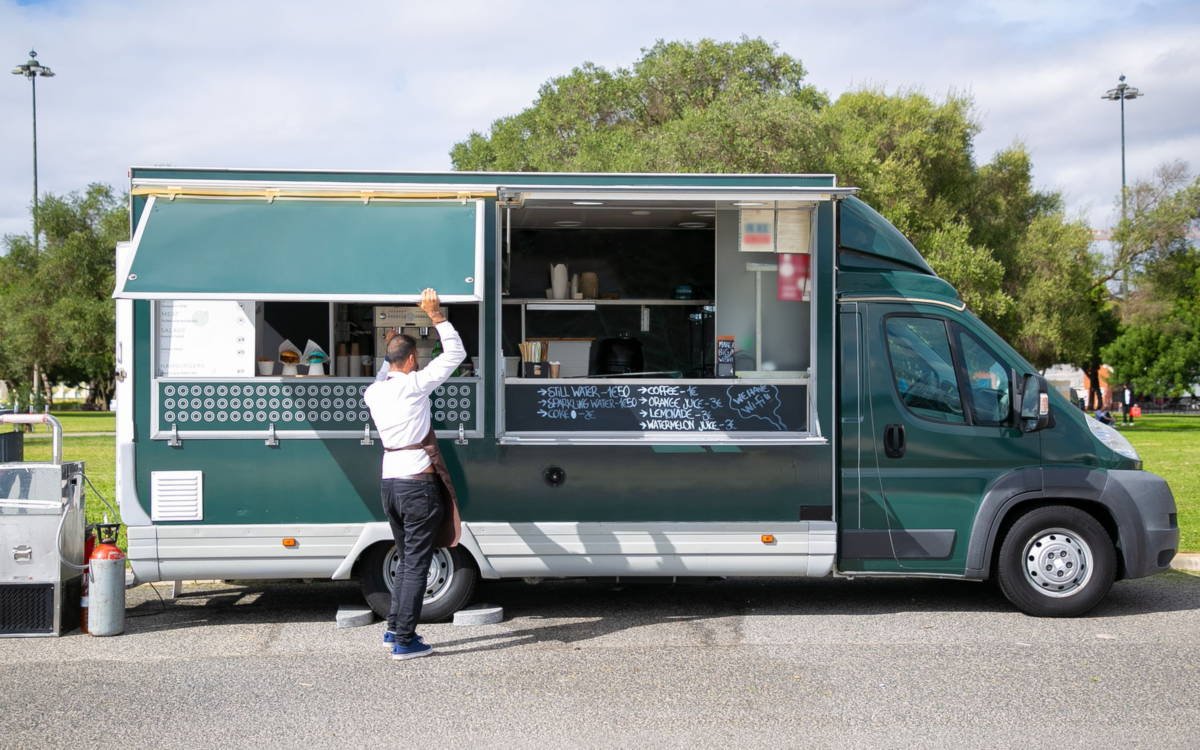 Professional food truck with open service hatch parked in a park