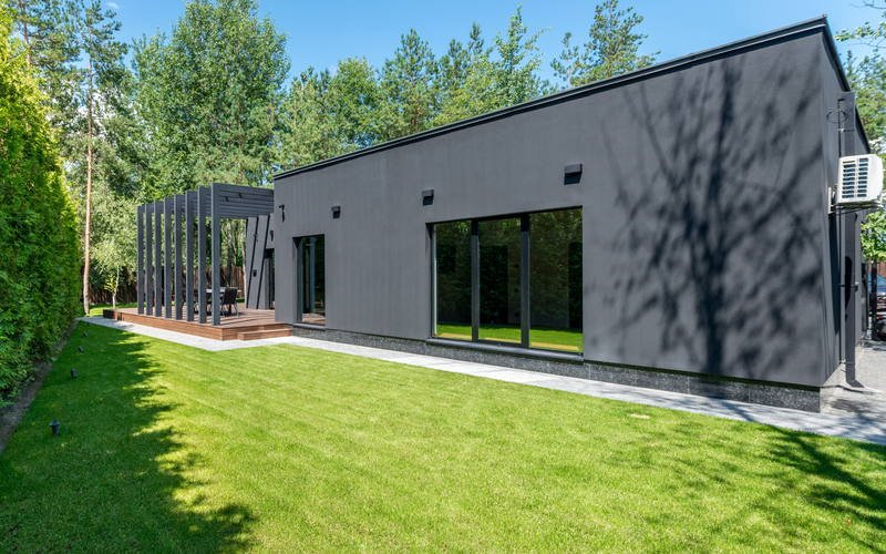 Row of modern modular buildings with anthracite frames and roller shutters